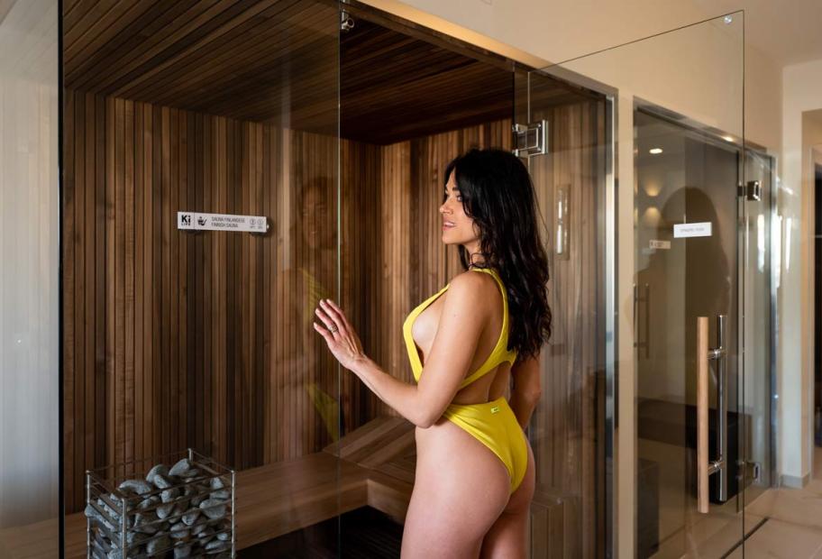 Donna in costume giallo, esplora una sauna con fascino ed eleganza.